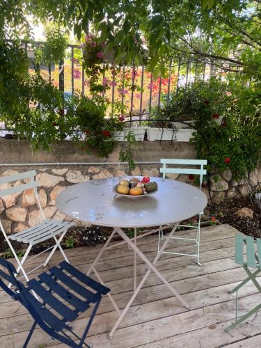 - une table et des chaises avec une assiette de fruits dans l'établissement שלווה בהר, à Malkiyya