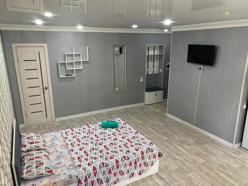 a bedroom with a bed and a tv in it at IZUMRUD in Petropavlovsk