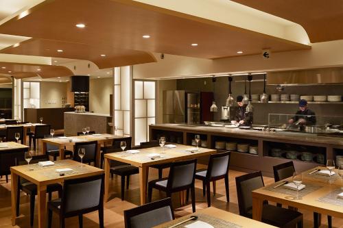 a restaurant with wooden tables and chairs and a kitchen at Laforet Hakone Gora Yunosumika in Hakone