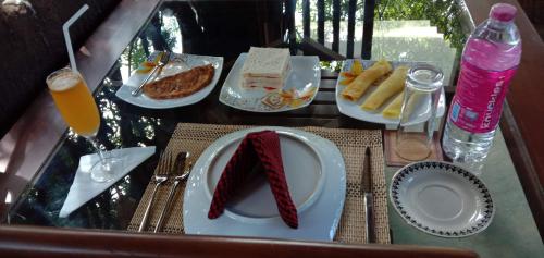 a table with plates of food on a table at Induwara Safari Resort in Udawalawe