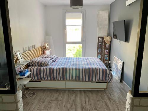 1 dormitorio con cama, escritorio y ventana en Bel appartement situé près des plages. en Marsella
