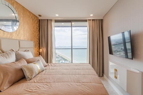 a bedroom with a large bed with a large window at Copacabana beach jomtien in Jomtien Beach