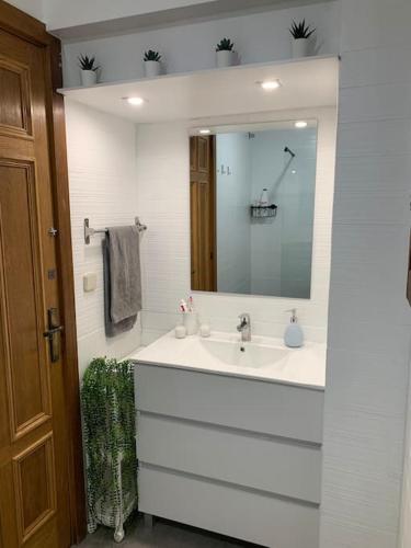 a white bathroom with a sink and a mirror at Cal Morenet in Palamós