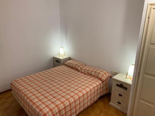 Un dormitorio pequeño con una cama y dos mesitas de noche. en Cal Morenet, en Palamós