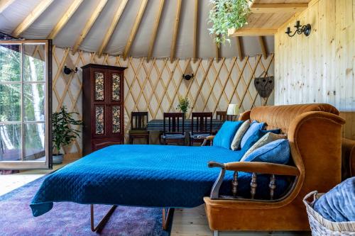 1 dormitorio con 1 cama con edredón azul en Jurta Pod Brzozami 