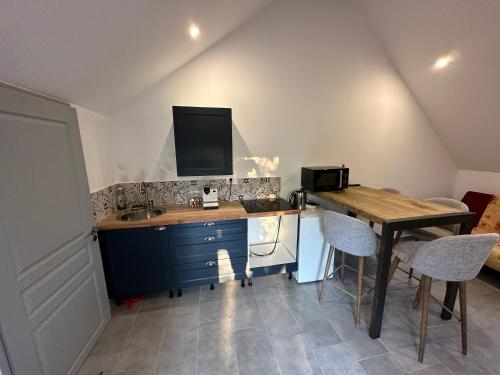 a kitchen with a desk and a table with chairs at Studio 2/4 à proximité de la loire in Les Ponts-de-Cé