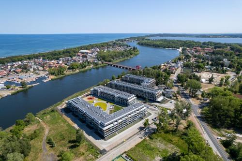 une vue aérienne sur un bâtiment à côté d'une rivière dans l'établissement Lux Wellness Resort & SPA Apartments by the River by Renters Prestige, à Dziwnów