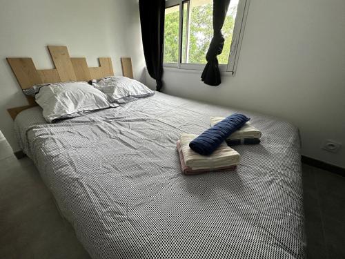uma cama com cabeceira em madeira e duas almofadas em Studio 2/4 à proximité de la loire em Les Ponts-de-Cé