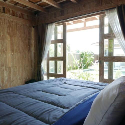 a large bed in a room with a window at Silir Villa "your cozy home" in Mataram
