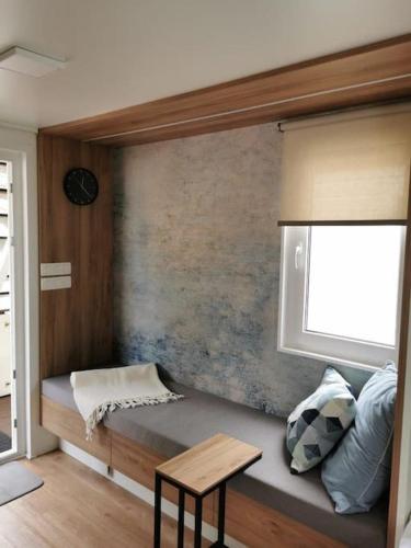 a room with a bench with a window and a table at Marinavita - a floating house in Portorož