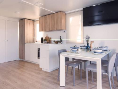a kitchen with a white table and chairs in it at Marinavita - a floating house in Portorož