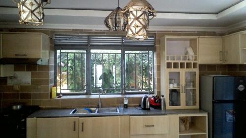 a kitchen with a sink and a large window at ARSENE ACCOMODATION AT Kwetu&Venus KIGALI in Kigali