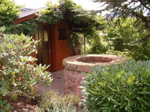 a garden with a stone wall in front of a cabin at Landhaus Schneider in Sasbachwalden