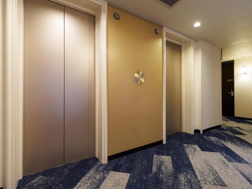 a row of elevator doors in a building at JR Kyushu Hotel Blossom Fukuoka in Fukuoka