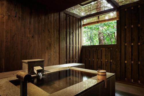 a wooden room with a bath tub and a window at Laforet Hakone Gora Yunosumika in Hakone