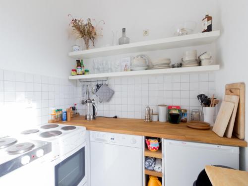 a kitchen with white appliances and white tiles at Wohnung Peter in Weimar