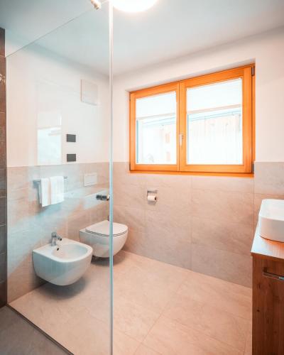 a bathroom with a sink and a toilet and a shower at Les Ciases Chalets Dolomites in San Vigilio Di Marebbe