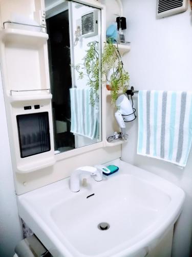 a bathroom with a white sink and a mirror at aup178 in Sapporo