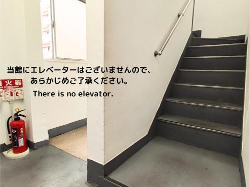 uma escada num edifício com um sinal que diz que não há elevador em Little Japan em Tóquio
