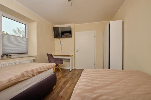 um quarto com uma cama, uma secretária e uma janela em Ferienwohnung Schwarting em Wiefelstede