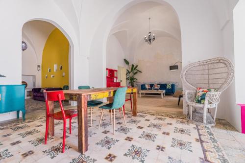 een eetkamer met een houten tafel en kleurrijke stoelen bij Casa delle Rondini in Presicce