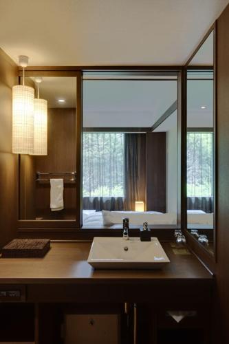 a bathroom with a sink and a large mirror at Laforet Hakone Gora Yunosumika in Hakone