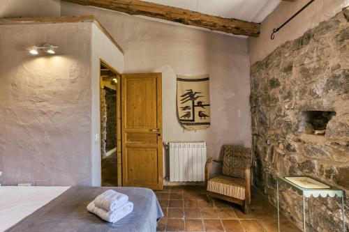 a bedroom with a bed and a stone wall at Casa de Pueblo in Cantallops