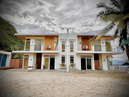 uma casa branca com uma palmeira em frente em Ohana beach house - Villa #2 em Cemento
