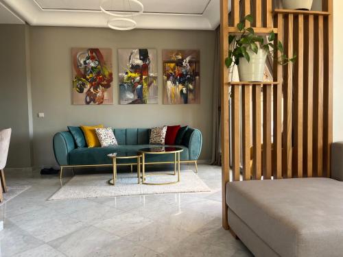 uma sala de estar com um sofá azul e uma mesa em Marrakech M Avenue CR 7 appart terrasse em Marrakech