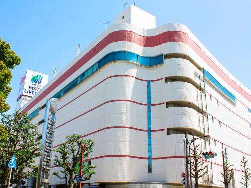 a large white building with colorful stripes on it at HOTEL LiVEMAX BUDGET Hamamatsu-Ekimae in Hamamatsu