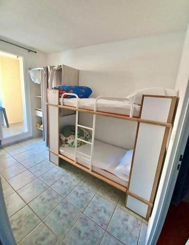 une chambre avec deux lits superposés dans une pièce dans l'établissement T3 grande terrasse bord de mer, au Barcarès