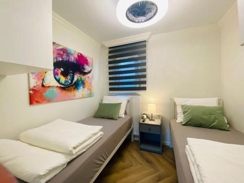 um quarto com duas camas e um quadro na parede em Ferienhaus LuxChalet VAJU IJsselView direkt am Fluss See Pool Park em Lathum