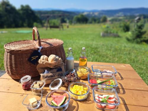 a picnic table with food and a basket on it at Barwald Hills in Wadowice