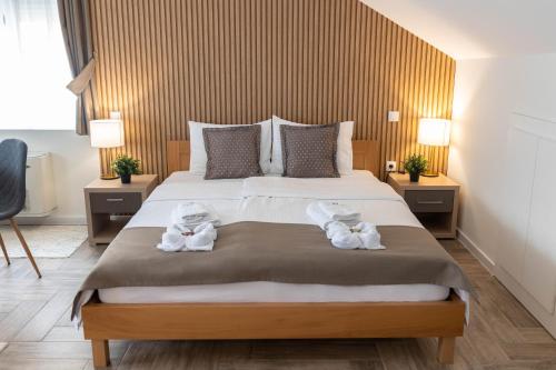 a bedroom with a large bed with towels on it at Zona Optimizma accommodation & SPA in Vršac