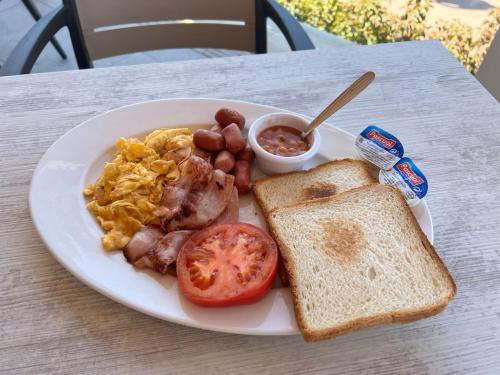 a plate of breakfast food with eggs bacon tomatoes and toast at Perla Marina in Nerja