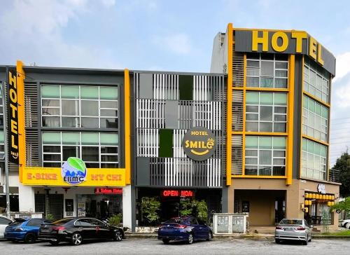 a hotel with cars parked in a parking lot at Smile Hotel Seri Kembangan in Seri Kembangan