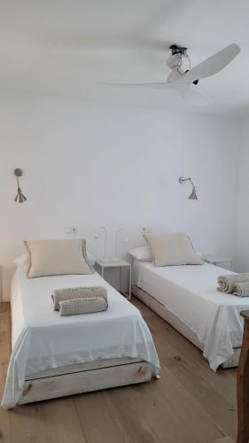two beds in a room with white walls at CASA MAGALI in Sant Francesc Xavier