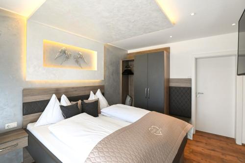 Un dormitorio con una cama grande con sábanas blancas. en Appartment Sun Chalet, en Schladming