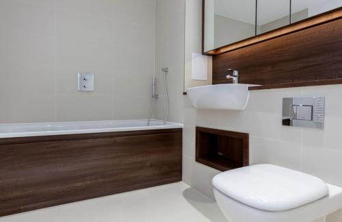 a bathroom with a toilet and a sink and a tub at The Unity in London