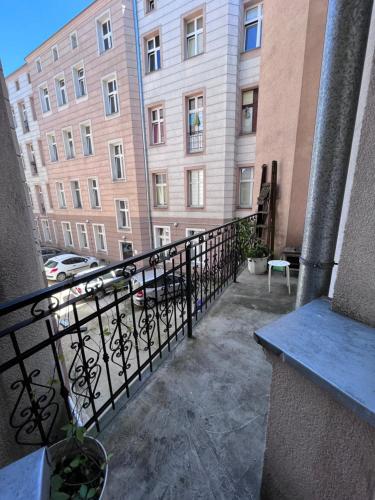 a balcony of a building with a fence and buildings at H. Kloss Rooms in Łódź