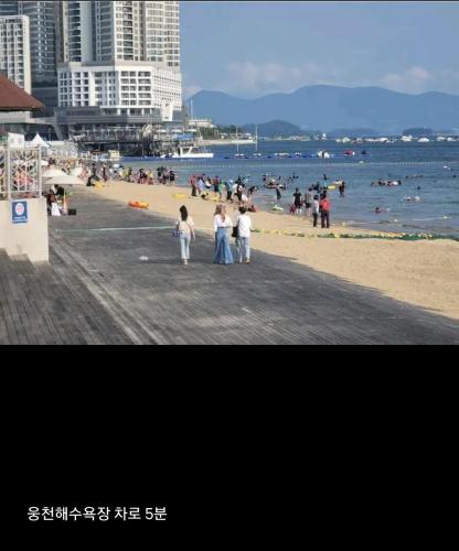 a group of people standing on a beach at Lotte Castle Marina in Yeosu