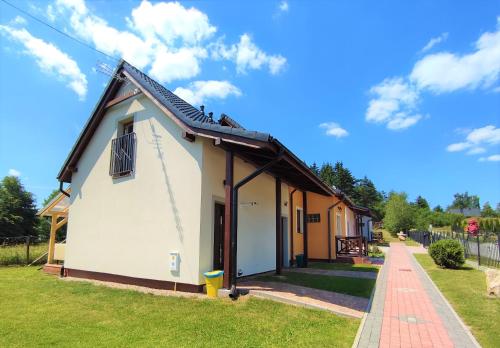 a small white building with a roof at Apartamenty Golden Village in Duszniki Zdrój