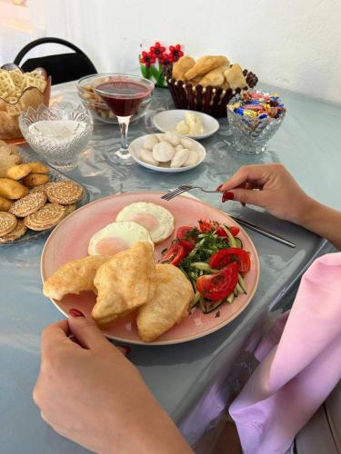 a table with a plate of food with a plate of food at Гостевой дом KOLSAY ROOM in Saty