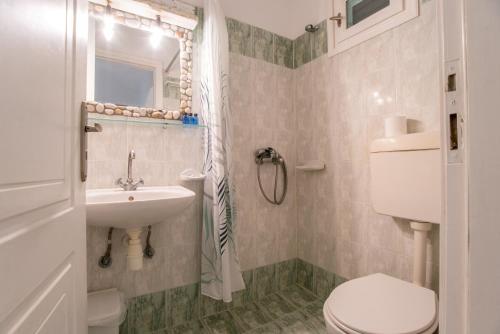 a bathroom with a toilet and a sink at Green Retreats 3 Paros in Isterni