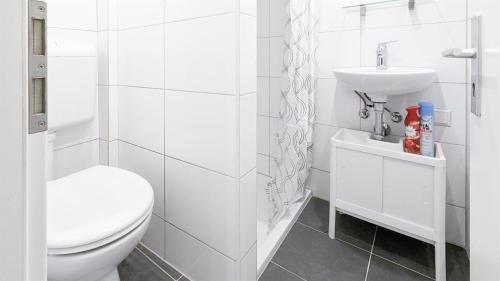 ein weißes Bad mit einem WC und einem Waschbecken in der Unterkunft ALFA Ludwigsburg City Apartment Zimmer 5 Personen Küche Netflix INET WM in Ludwigsburg
