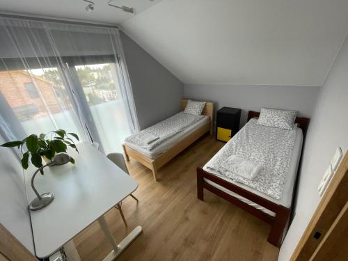 兹邦申Apartament_Zbąszyń的有两张床和一张桌子的小房间