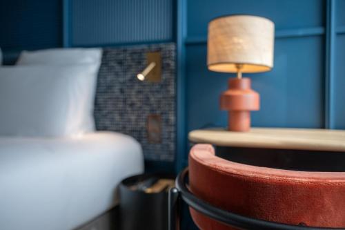 a lamp sitting on a table next to a bed at Mercure La Rochelle Vieux Port in La Rochelle