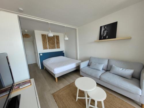 - un petit salon avec un canapé et un lit dans l'établissement Blue Sea Vue mer - Village naturiste Héliopolis, au Cap d'Agde