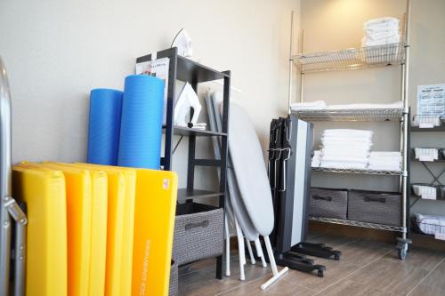 a room with yellow and blue surfboards and shelves at 3 Wellness in Okayama