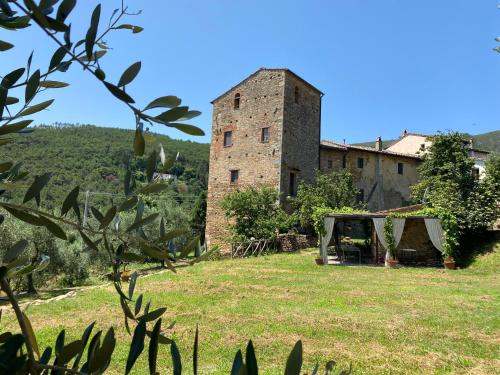 an old building in a field with a tent at Torre BALDUCCI in Vicopisano